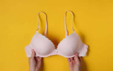 Stüdyonun arka planında kadın eli sutyenleri tutuyor. Üst görünüm