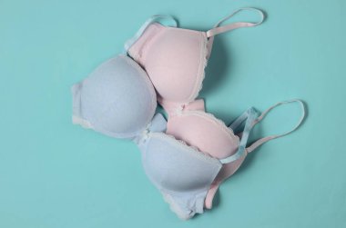 Mavi pastel arka planda iki şık sütyen. Üst Manzara. Güzellik ve moda minimalist natüralistik hayat