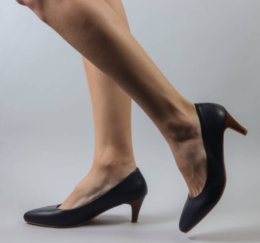 Beyaz arka planda klasik yüksek topuklu ayakkabılı ince kadın bacakları. Stüdyo moda çekimi