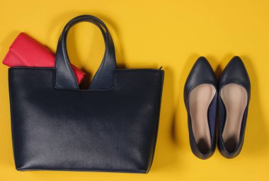 Çanta, çanta, sarı arka planda yüksek topuklu ayakkabılar. Kadının günlük kıyafetinin genel görünüşü. Moda kadın aksesuarları. Düz yatış, üst görünüm.