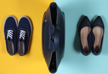 Deri çanta mavi-sarı arka planda spor ayakkabılar ve klasik yüksek topuklu ayakkabılar. Üst görünüm