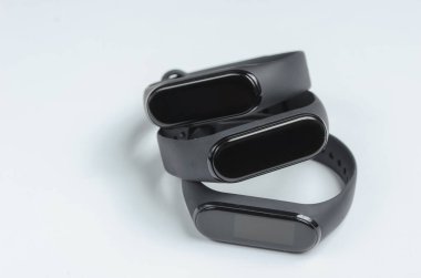 Beyaz arka planda üç akıllı bilezik. Spor ve günlük aktiviteler için modern aletler