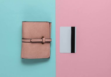 Cüzdan ve banka kartı mavi-pembe renkli arka planda. Üst görünüm