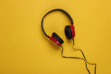 Sarı arka planda kablolu kulaklıklar. Müzik aşığı kavramı.