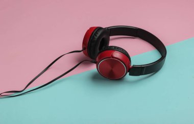 Modern kulaklıklar pembe mavi pastel arka planda. Müzik aşığı kavramı.