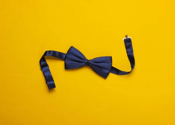 Bow tie on a yellow paper background. Top view.