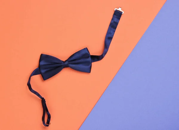 Bow tie on colored paper background. Top view.