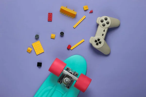 Koncepcja Dzieciństwa Rozrywki Deska Krążownicza Gamepad Cegły Zabawki Fioletowym Tle — Zdjęcie stockowe