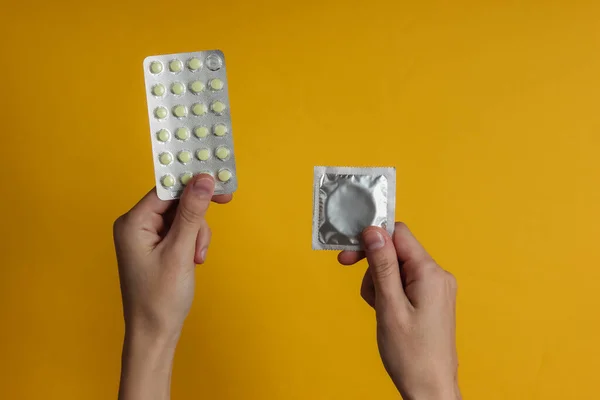 Hand Holds Condoms Packaging Birth Control Pills Yellow Background Top — Stock Photo, Image