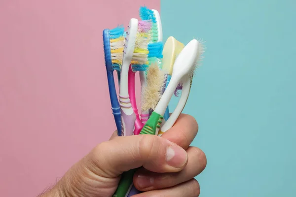 Mão Segurando Monte Velhas Escovas Dentes Usadas Fundo Pastel Azul — Fotografia de Stock