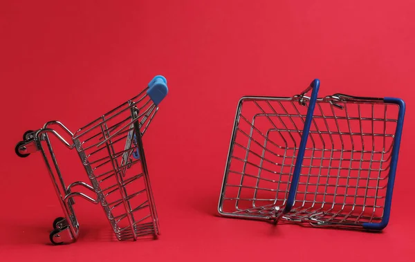 Minimalistic shopping concept. Shopping trolley, basket on red background.