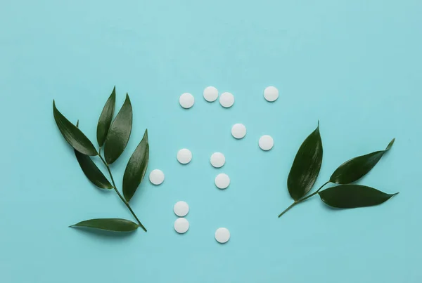 Ziołowe Pigułki Białe Tabletki Zielonymi Liśćmi Niebieskim Pastelowym Tle Medycyna — Zdjęcie stockowe