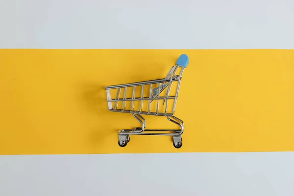 简约购物的概念 白色和黄色背景的购物车 — 图库照片