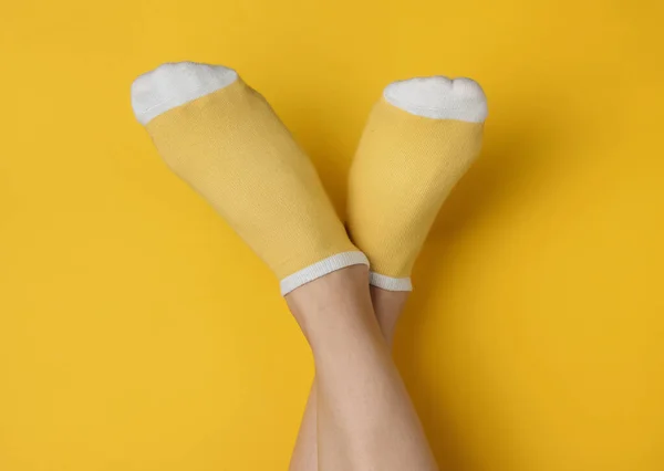 Patas Femeninas Con Calcetines Amarillos Sobre Fondo Amarillo Estudio Concepto — Foto de Stock