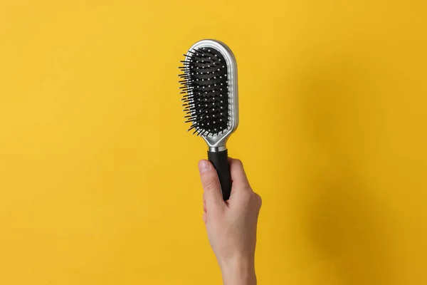 Mano Femenina Sostiene Peine Sobre Fondo Amarillo Cuidado Del Cabello —  Fotos de Stock