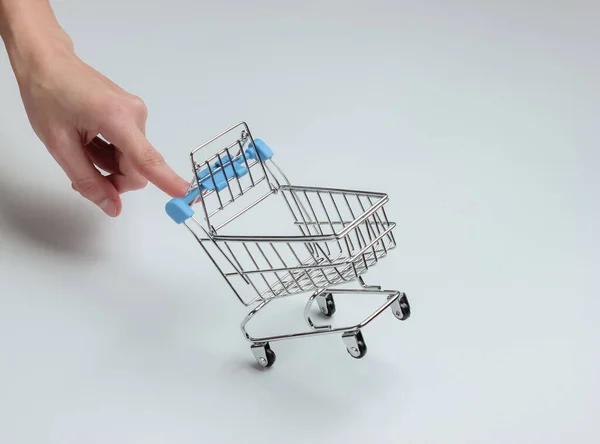 Minimalisme Winkelconcept Vrouwelijke Hand Houdt Mini Winkelwagentje Witte Achtergrond — Stockfoto