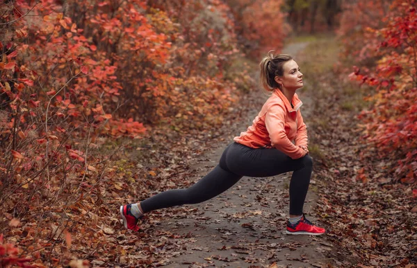 Молодая Привлекательная Спортсменка Спортивной Одежде Делает Упражнения Ноги Осеннем Лесу — стоковое фото