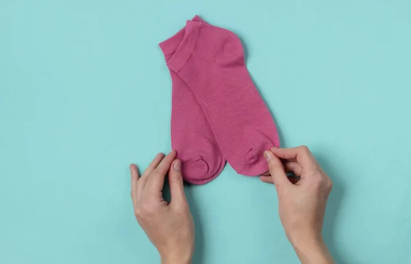 Weibliche Hände Mit Rosa Socken Auf Blauem Hintergrund Ansicht Von — Stockfoto