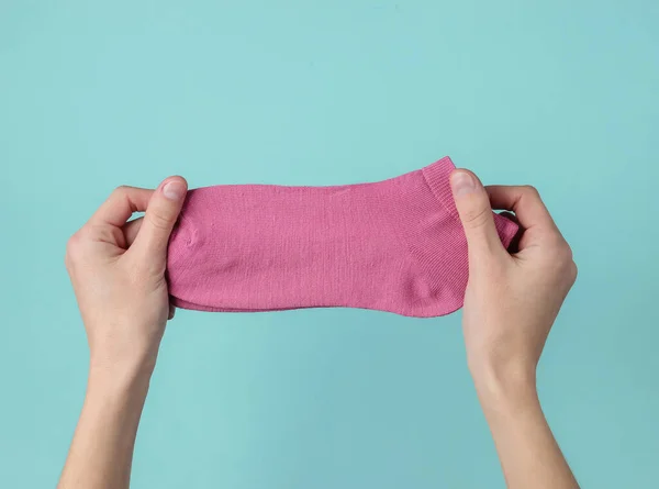 Manos Femeninas Sosteniendo Calcetines Rosas Sobre Fondo Azul Vista Superior — Foto de Stock