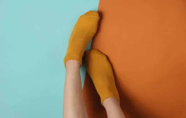 Patas Delgadas Femeninas Calcetines Naranjas Sobre Fondo Azul Marrón Vista — Foto de Stock
