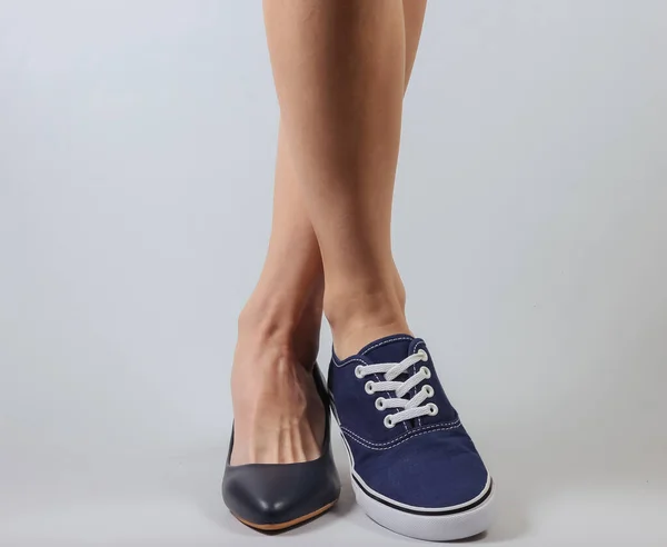 Slanke Vrouwenbenen Twee Verschillende Schoenen Met Hakken Sneakers Een Witte — Stockfoto