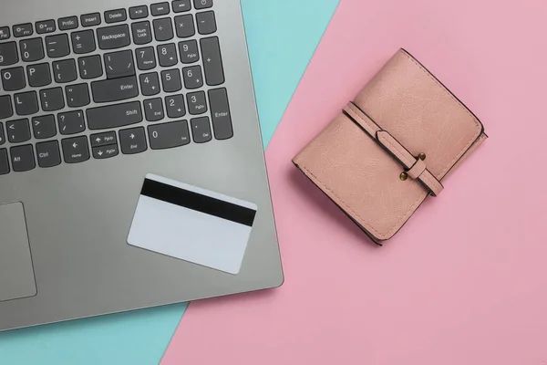 笔记本电脑 钱包和银行卡粉红色的蓝色粉刷背景 网上购物 顶部视图 最低限度主义 — 图库照片