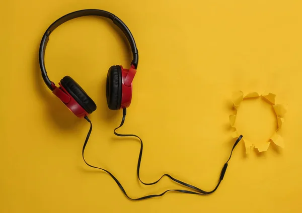 Κομψά Ενσύρματα Ακουστικά Κίτρινο Φόντο Μέσα Από Σχισμένη Τρύπα Στο — Φωτογραφία Αρχείου