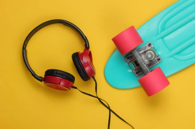 Kruvazör tahtası, sarı arka planda kulaklıklar. Yaz eğlencesi. Retro tarzı. 80 'ler. Üst görünüm