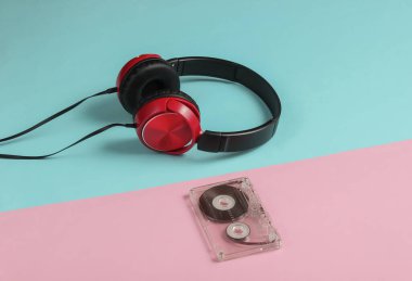 Üzerinde mavi pastel arka planda ses kaseti olan kablolu kulaklıklar. Retro tarzı DJ. Minimalist müzik konsepti.