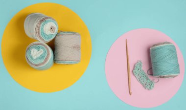 İplikli yün iplikler ve mavi arkaplanlı ahşap bir kanca. Üst Manzara. Hobiler