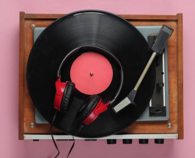 Eski moda vinil çalar, pembe pastel arka planda kulaklıklar. Medya 70 'ler.