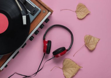 Eski moda vinil çalar, pembe pastel arka planda kulaklıklar. Medya 70 'ler.