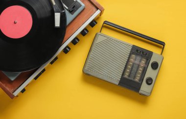 Retro radyo alıcısı, sarı arka planda eski moda vinil çalar. Medya 70 'ler. Üst görünüm