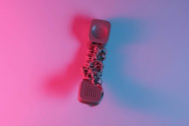 Eski moda bir cep telefonu. Kırmızı-mavi neon eğimli ışık. Retro dalga, popüler kültür. Üst görünüm