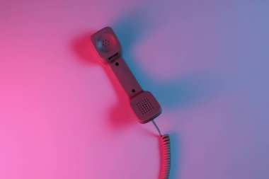 Eski moda bir cep telefonu. Kırmızı-mavi neon eğimli ışık. Retro dalga, popüler kültür. Üst görünüm