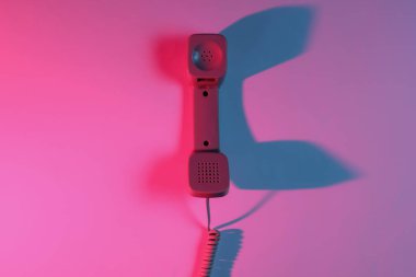 Eski moda bir cep telefonu. Kırmızı-mavi neon eğimli ışık. Retro dalga, popüler kültür. Üst görünüm