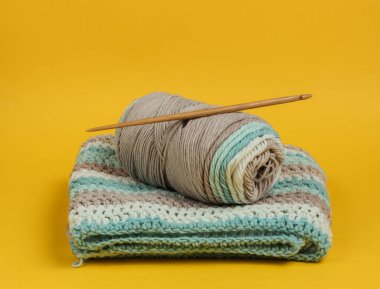 Yünlü iplikler ve sarı arkaplanda örgü örmek için ahşap örgü..