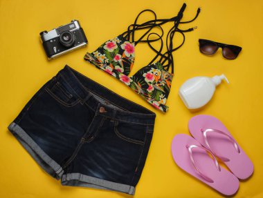 Yaz eğlencesi geçmişi. Sarı arka planda yaz plajı aksesuarları. Üst Manzara. Düz yatış stili. Minimalizm