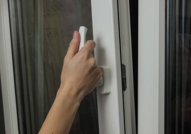 Kadın eli havalandırma için metal plastik bir pencere açar.