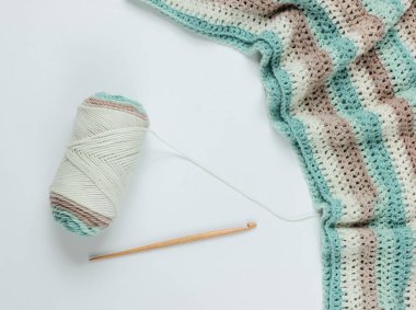 Beyaz arka planda yün iplikler ve ahşap örgü kancası. Üst Manzara. Hobiler