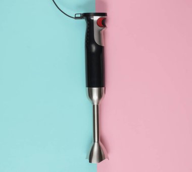 Pembe mavi pastel arka planda elektrikli el blenderi. Üst görünüm