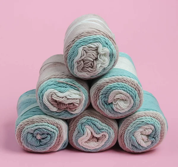 Pembe pastel arka planda yünlü iplikler yığını