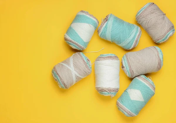 Sarı stüdyo arka planında bir sürü yün renkli iplik var. Üst Manzara. Stüdyo çekimi. Hobi ev yapımı