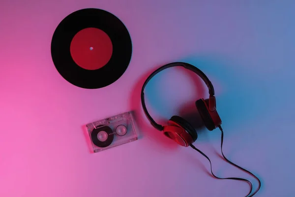 有線ヘッドフォン ビニールレコード ネオン青赤グラデーションライト付きオーディオカセット レトロな波 80年代ポップカルチャー トップ表示 — ストック写真