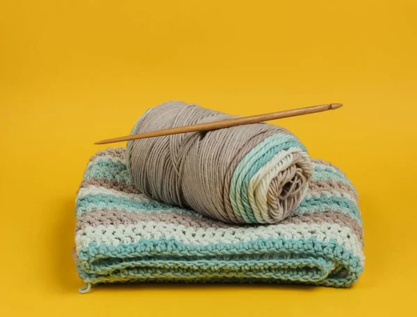 Yünlü iplikler ve sarı arkaplanda örgü örmek için ahşap örgü..