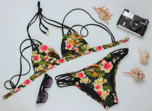 Beyaz arka planda kadın mayosu ve plaj aksesuarları. Kadın mayosunun yukarıdan görünüşü. Yaz arkaplanı, sahilde tatil. Düz yatış, üst görünüm. 