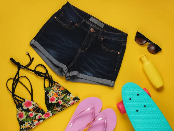 Yaz eğlencesi geçmişi. Sarı arka planda yaz plajı aksesuarları. Üst Manzara. Düz yatış stili. Minimalizm