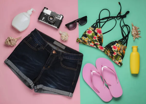 Kadın mayosunun yukarıdan görünüşü. Yaz eğlencesi geçmişi. Pembe pastel arka planda yaz plajı aksesuarları. Üst Manzara. Düzleştirme biçimi. 