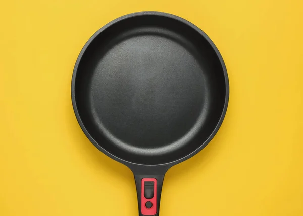黄色の背景にノンスティックコーティングでフライパンを炒める 料理ミニマリズムの概念 トップ表示 — ストック写真