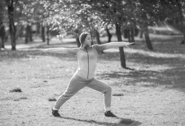 Genç sporcu kadın sonbahar parkında yoga yapıyor.